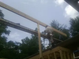 Carpenter setting a ridge beam over a new addition frame — Ice Dam Removal by Roofing Brothers in Briarcliff Manor