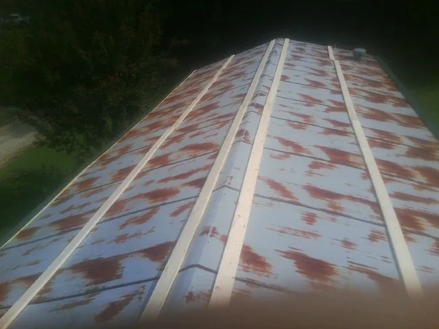 Rusted metal roof panels with new wood purlins before replacement — Storm Damage Roof Repair in Briarcliff Manor by Roofing Brothers