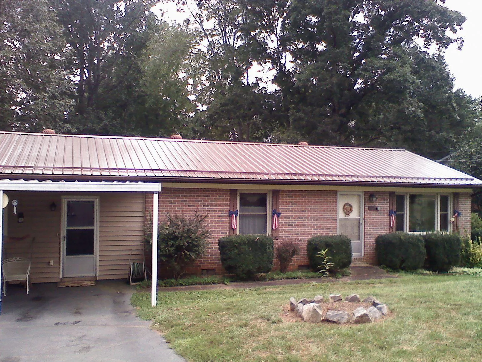 Bronze metal roof and carport on a brick ranch home — Roof Repair work by our crew in Briarcliff Manor